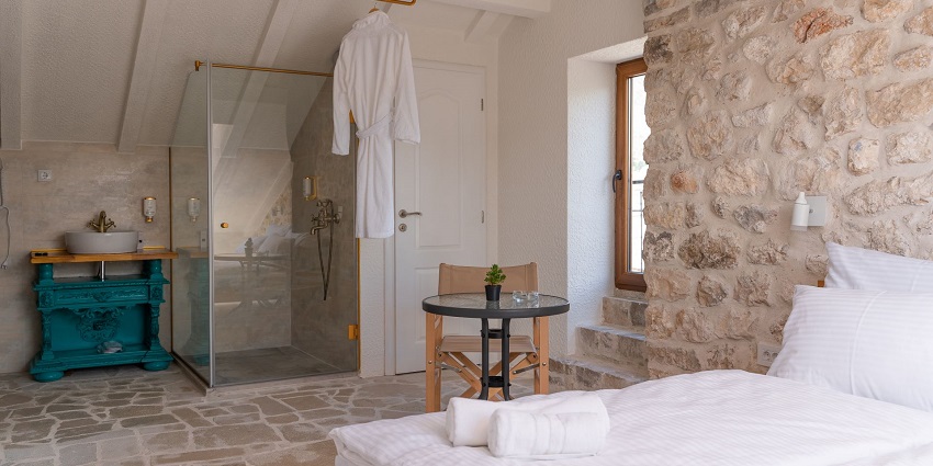  Image of a hotel room with a bedside washroom and clean sheets