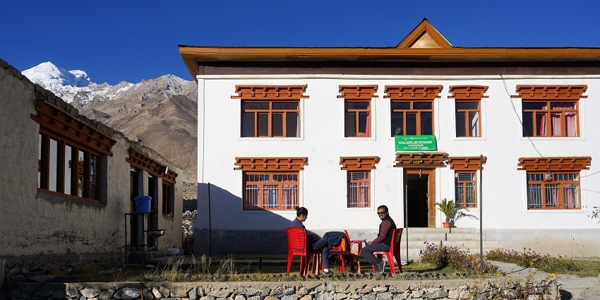 A breathtaking view of a hotel in Ladakh with stunning views of the snow-capped mountains.