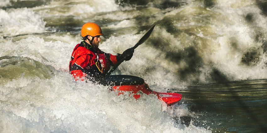A glimpse of a person indulging in white water rafting amidst the shimmering waters.