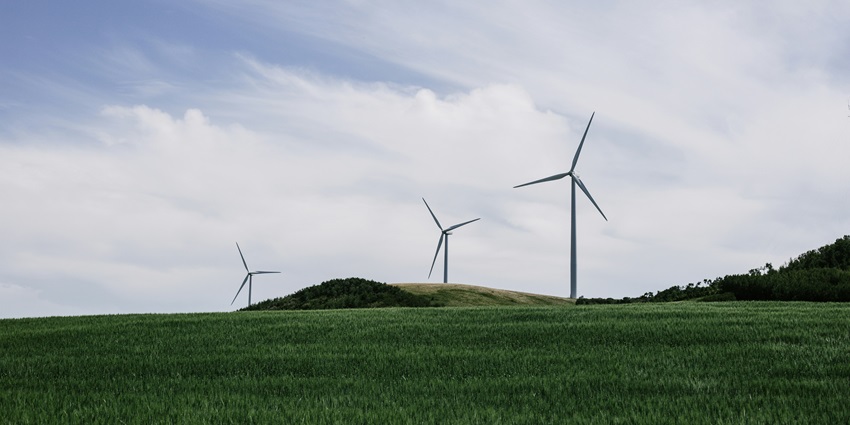 A scenic view of windmills on the lush green grounds of Chalkewadi Windmill Farm.