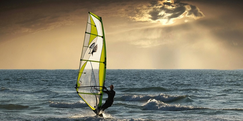 A picture of a man surfing across the waves, the most thrilling Chivla Beach Sea Water Sports.