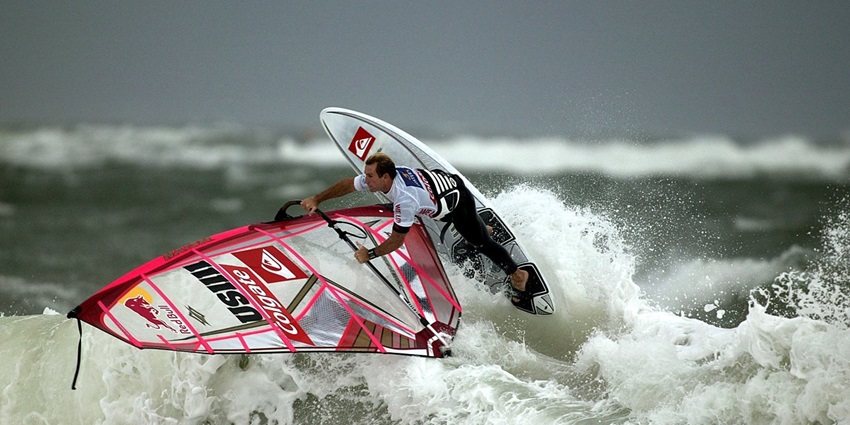 Windsurfing adventure combining sailing and surfing, riding waves with wind-powered sails.