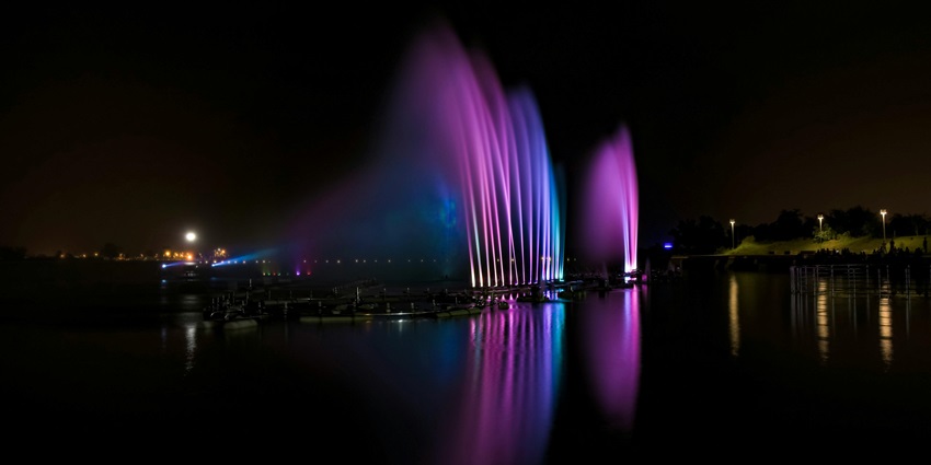 An evening view of the Fountain of Fortune, splashing waters and adorned with colours.