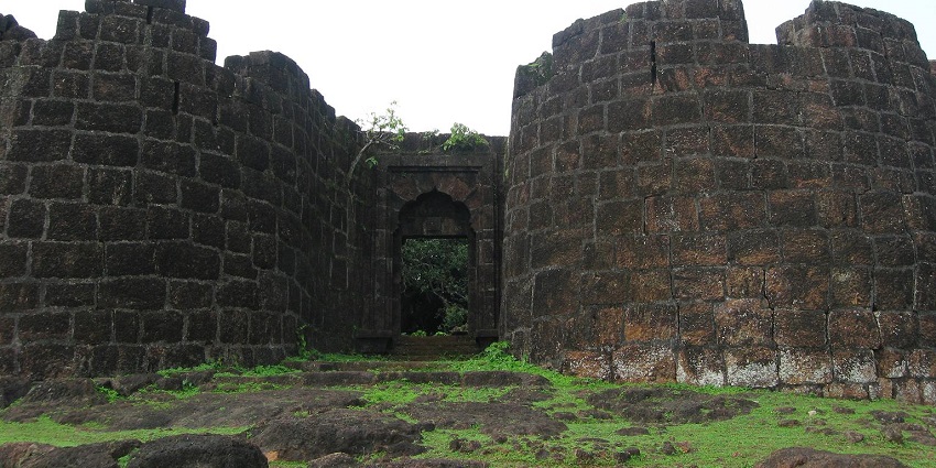 A serene view of the Bankot Fort exuding old-world charm, nestled amidst lush greenery.