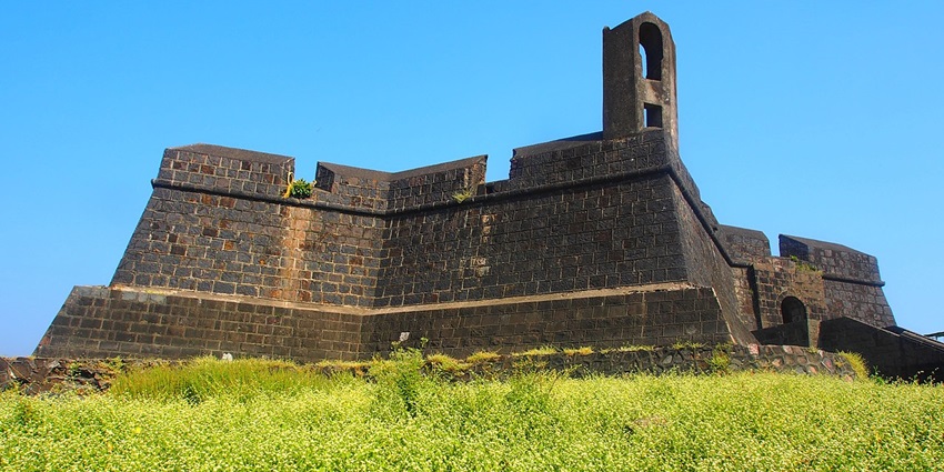 An image of a historic Worli Fort overlooking the sea with stone walls and a panoramic coastal view.