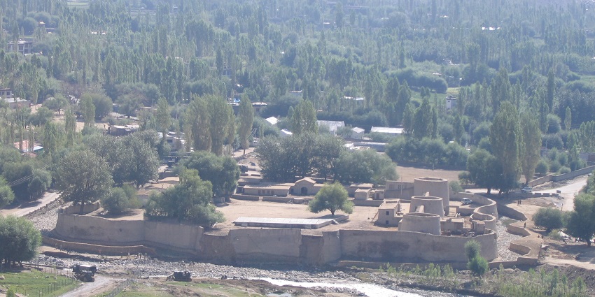 A picture of a fort in Leh, surrounded by greenery and trees