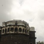 Majestic view of Ambagad Fort atop a hill surrounded by lush greenery.