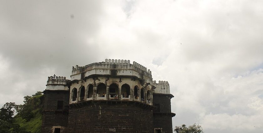 Majestic view of Ambagad Fort atop a hill surrounded by lush greenery.