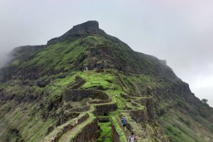 Majestic view of Asherigad Fort atop a hill surrounded by lush greenery