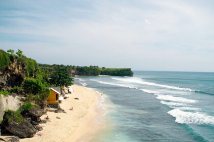 An image of Balangan Beach with pristine golden sands and waves crashing along the shore.