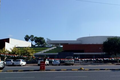 The front view of Bihar museum from a distance while a man on a bicycle passes by