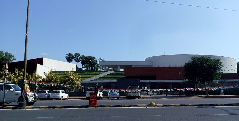 The front view of Bihar museum from a distance while a man on a bicycle passes by