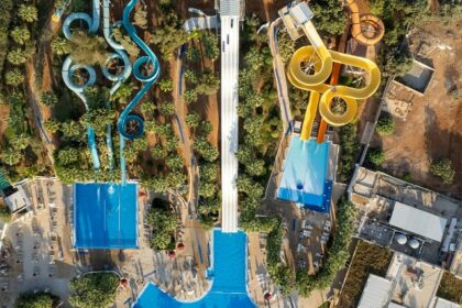 A bird’s eye view of a leisure hub featuring lush green vegetation and colourful rides.