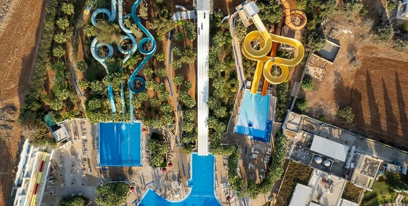 A bird’s eye view of a leisure hub featuring lush green vegetation and colourful rides.