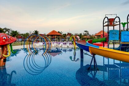 Children squealing with delight while sliding down colourful water slides at the water park in Pune