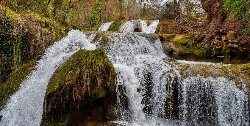 The Khandi Waterfalls is a natural marvel surrounded by greenery and rocky terrain.