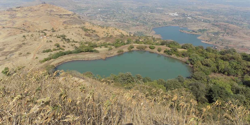 A panoramic view of Anjaneri Mountain with greenery under a clear blue sky.