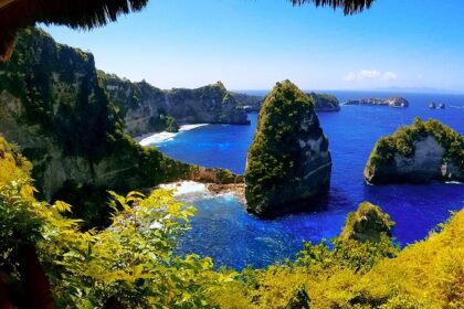 The view of this sland from inside a cave with rugged cliffs, one of the best places to visit in Nusa Penida.