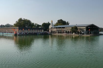 A picture of a temple in Solapur with a lake surrounding it