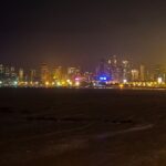 A picture of the Mumbai skyline, featuring illuminated buildings and the iconic curve of the Queen's Necklace.