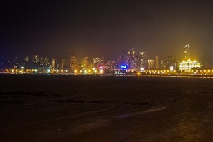 A picture of the Mumbai skyline, featuring illuminated buildings and the iconic curve of the Queen's Necklace.