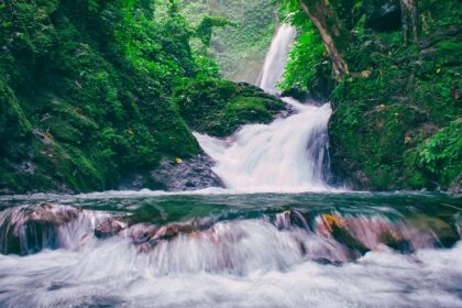 The breathtaking Vajrai Waterfalls flowing down a mountain, framed by greenery and rocky terrain.