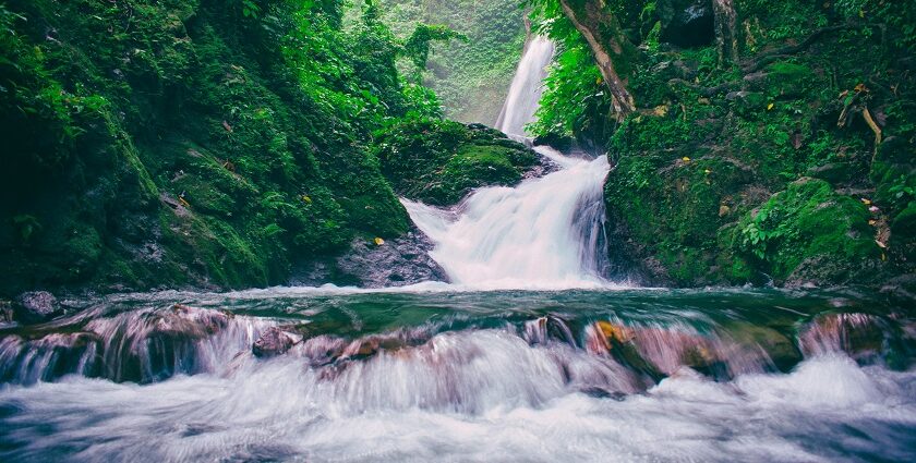 The breathtaking Vajrai Waterfalls flowing down a mountain, framed by greenery and rocky terrain.