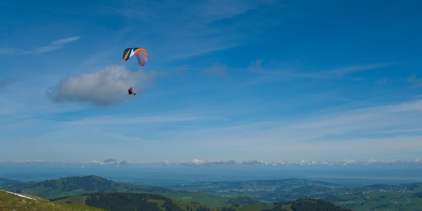 A paraglider soaring over stunning mountain landscapes.