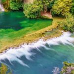 A panoramic view of the Waghora Waterfalls cascading amidst greenery.