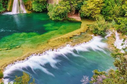 A panoramic view of the Waghora Waterfalls cascading amidst greenery.