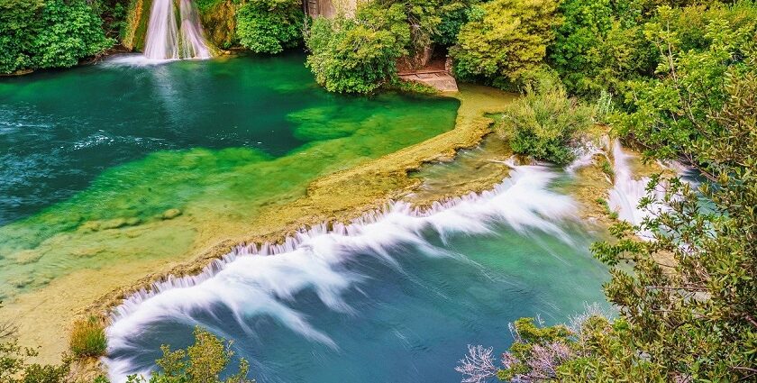 A panoramic view of the Waghora Waterfalls cascading amidst greenery.