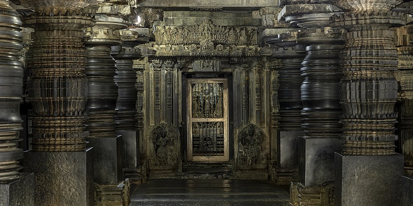 A picture of a traditionally built temple with intricate pillars in the main hall