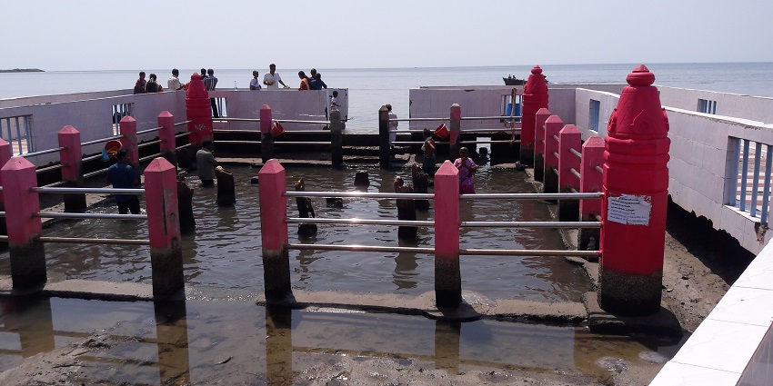 Images of Navagraha partially submerged inside the sea with people coming to seek blessing