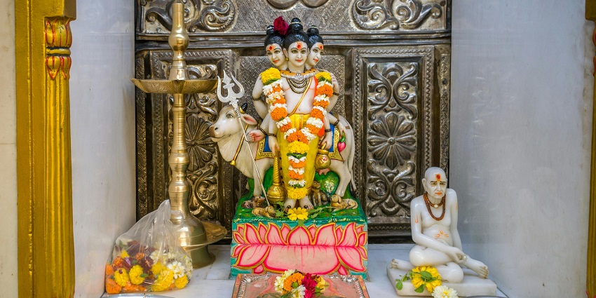 A picture of a temple with idols of different Hindu deities decorated with flowers and garlands