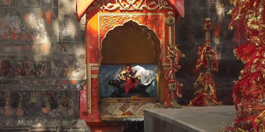 A picture of the idol of goddess Vajreshwari decorated with flowers and garlands at a temple