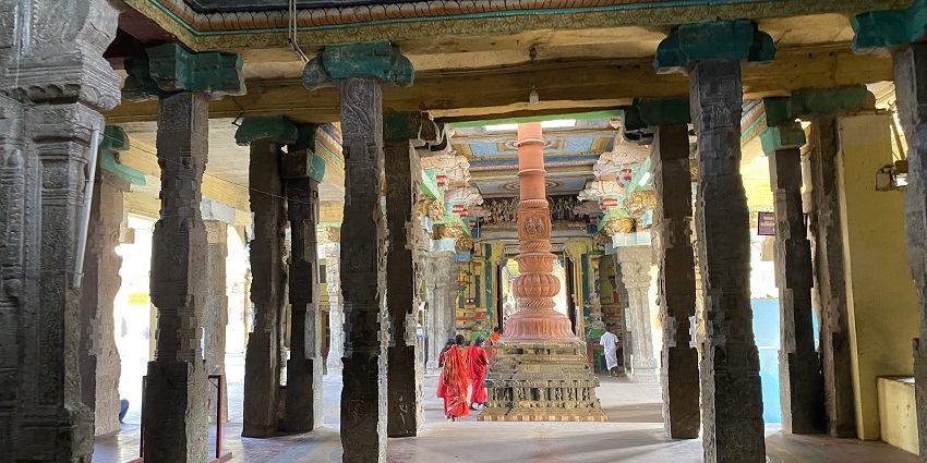 Halls of Adi Kumbeswarar Temple with visitors exploring intricate carvings and statues