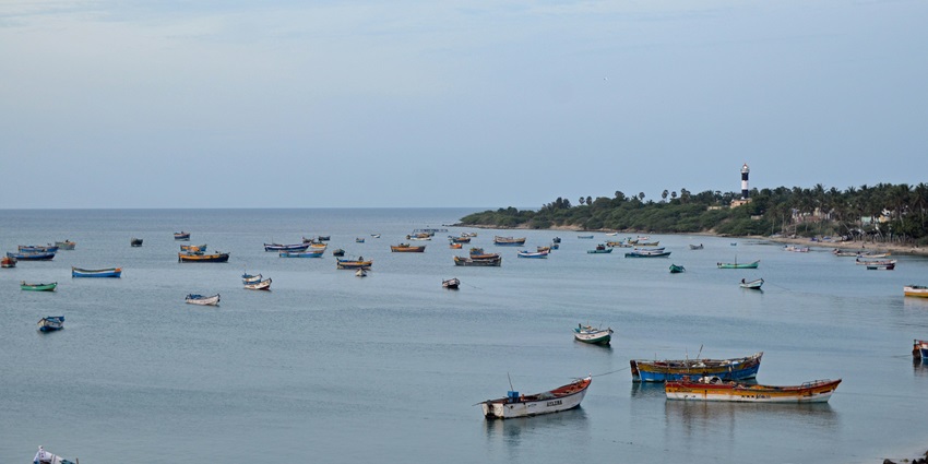 The view of the beach with gentle waves and several boats offers a stunning view.