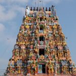 The entrance tower of Alangudi Temple with colourful sculptures and a designed chariot.