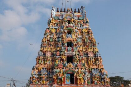 The entrance tower of Alangudi Temple with colourful sculptures and a designed chariot.