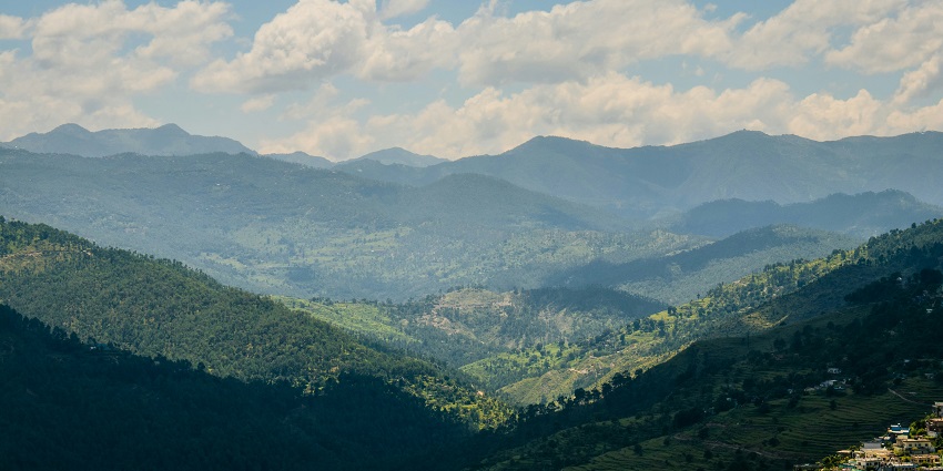 A beautiful sunset over the Almora skyline, featuring vibrant orange and purple hues in the sky.