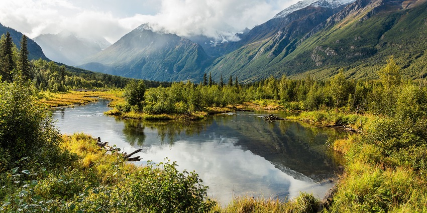 A photo of a beautiful river in Alaska with mountains in the background