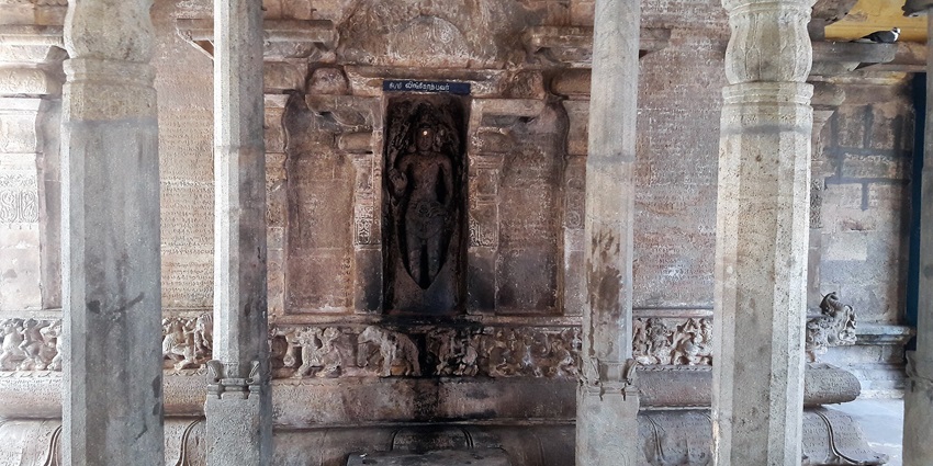 A structure of a deity carved in the centre of a wall with inscriptions on both sides