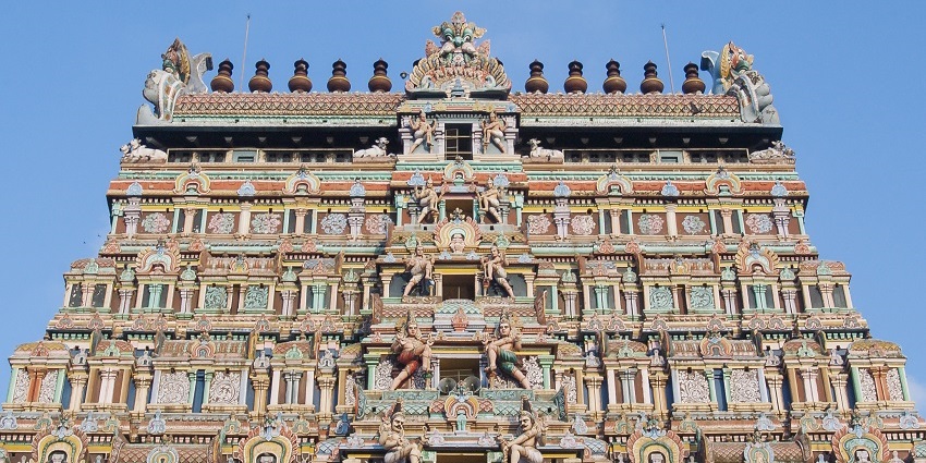 Colourful, intricately carved facade of Arulmigu Avinashiappar Temple against the blue sky