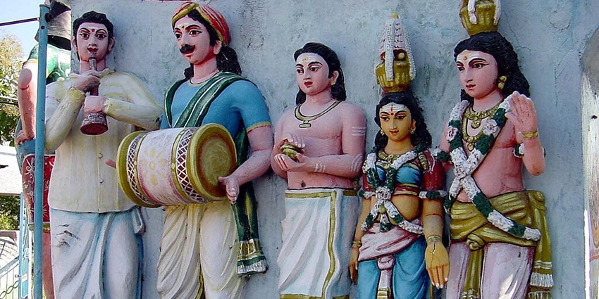 Sculpted human-sized dolls of companions of Ayyanar against the wall of a Madurai temple.