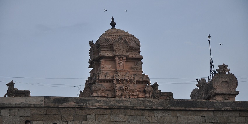 A picture of a historical temple, surrounded by greenery, taken during twilight hour