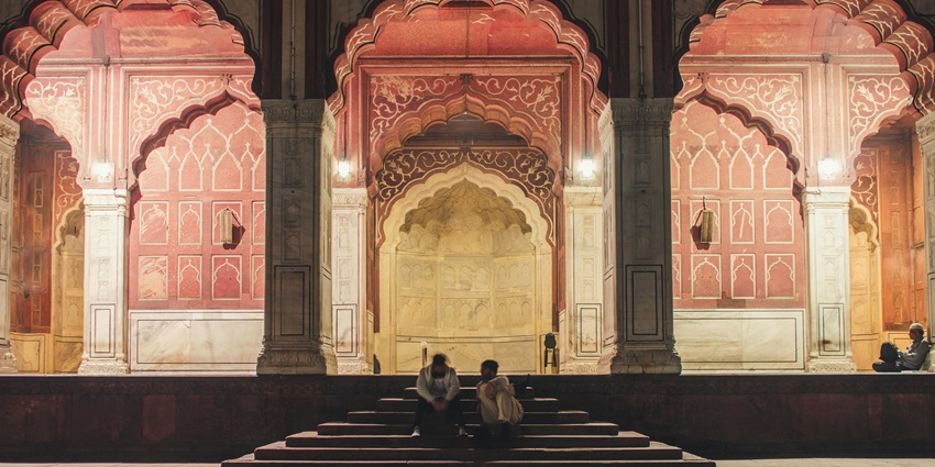 A view of two people sitting closely on temple stairs in Pondicherry. India.