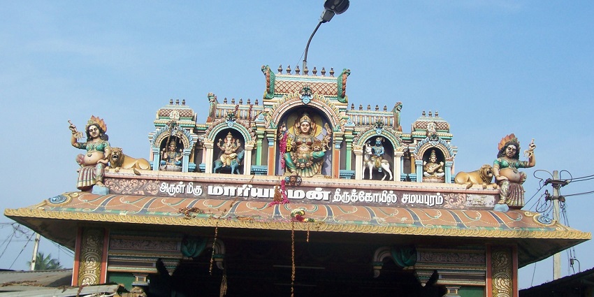 Entrance of Samayapuram Mariamman Temple featuring idols of deities and lion statues.