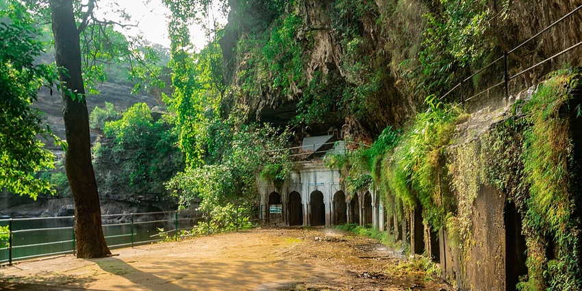Image of the Arvalem Caves surrounded by lush greenery and moss, a famous historical spot nearby.