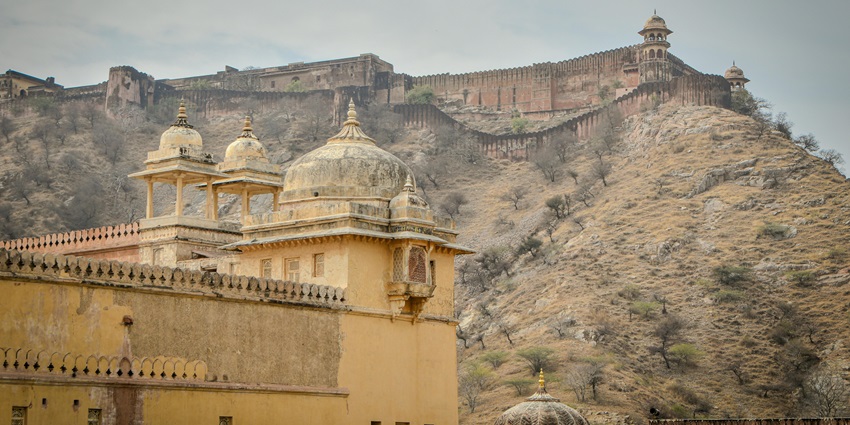 Asrauli Fort in Bulandshahr with crumbling façade, arched gateways, and overgrown surroundings reflecting historic decay.