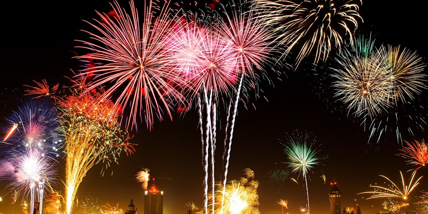 Vibrant fireworks illuminates skyline against a dark sky, similar to festival celebrations